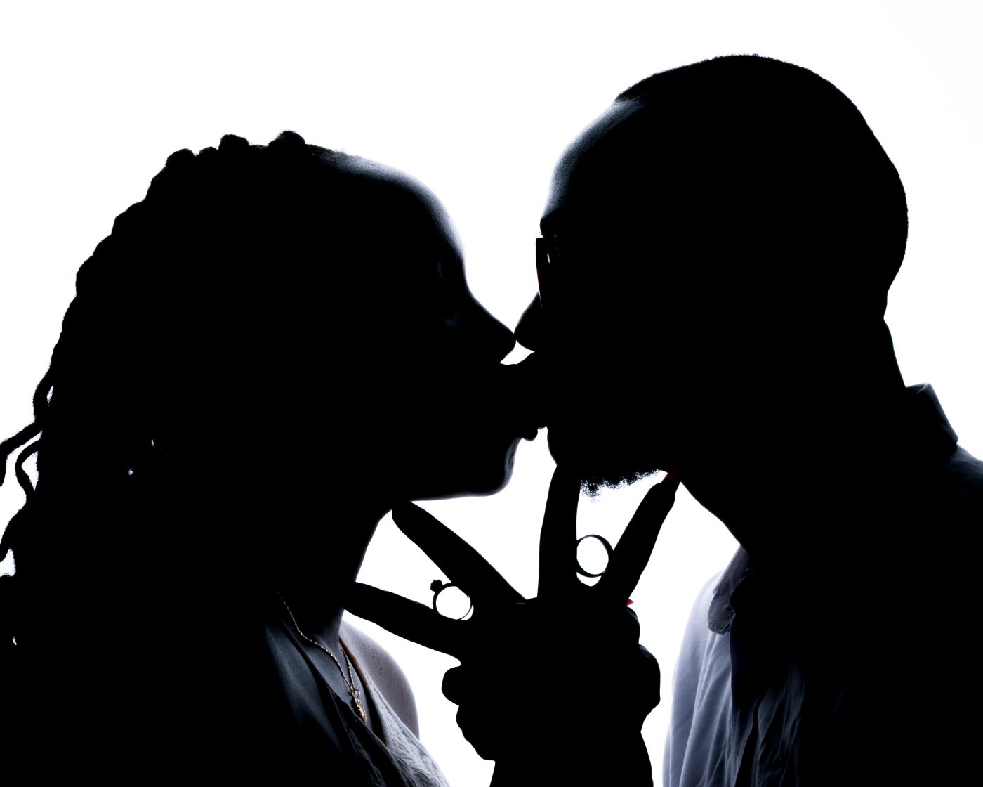 A romantic couple photoshoot at Mint Glint Studio, the best photostudio in Nairobi, featuring a high-contrast silhouette of a couple kissing against a bright white background.