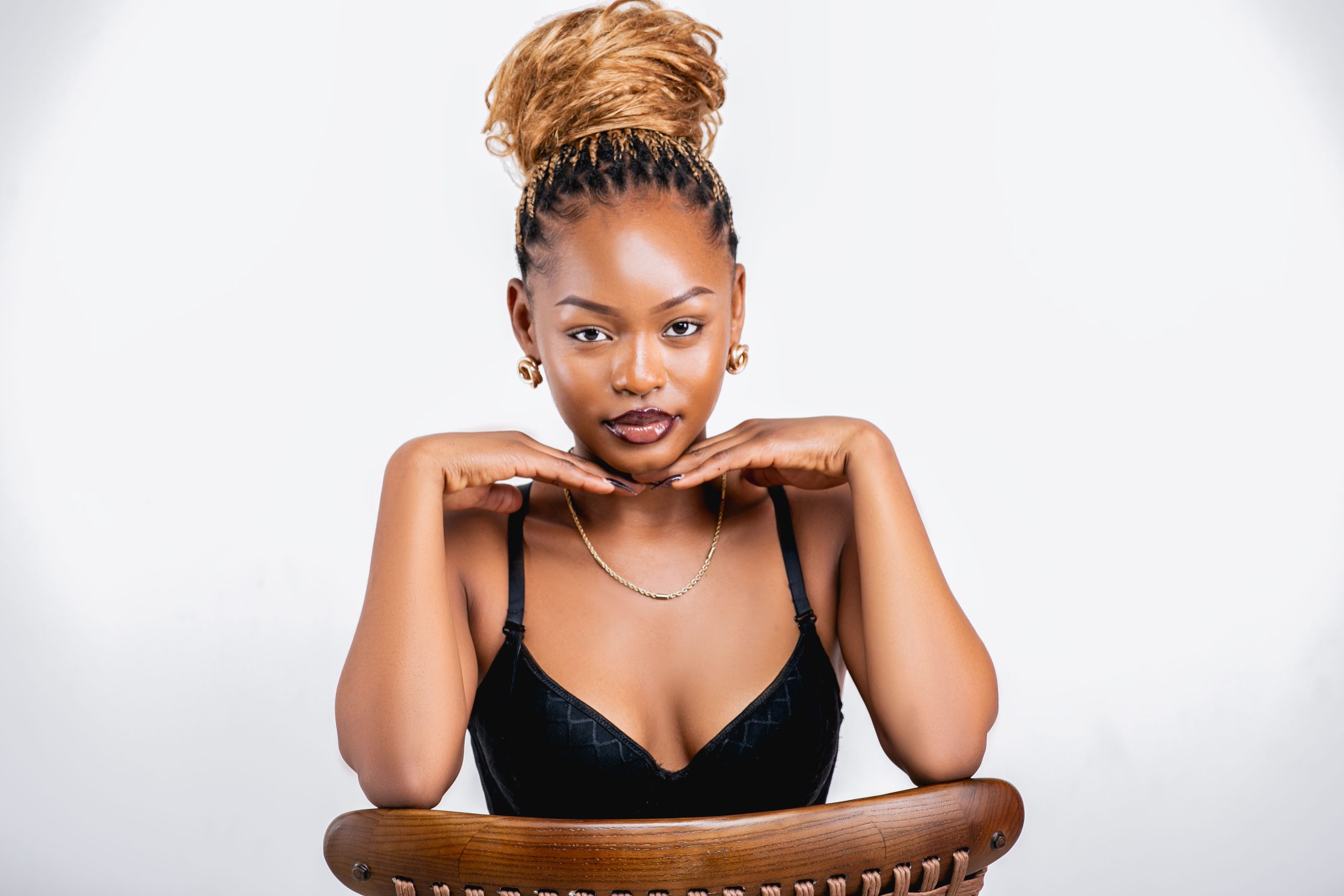 Beauty portrait of a woman with a high bun and gold jewelry at MintGlint Studios.